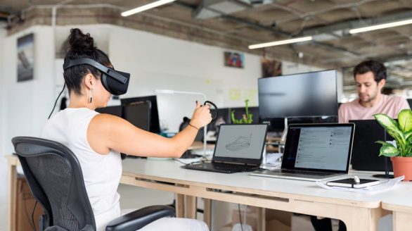 Woman using virtual reality headset in a modern office for design and innovation.