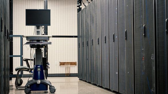 Contemporary computer on support between telecommunication racks and cabinets in modern data center