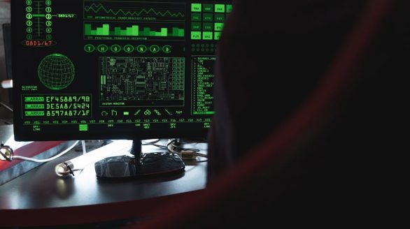 View of a computer monitor displaying green digital security code in an indoor setting.